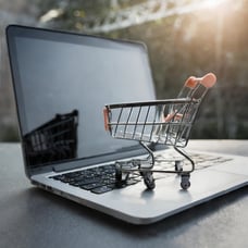 AI genererad shoppingvagn i miniatyr som står på en laptop.